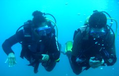 Two divers compare the direction as they practice navigating underwater in Gran Canaria